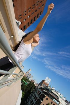 A young adult woman practicing Yoga in an urban environment.