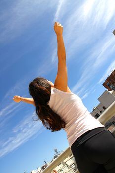 A young adult woman practicing Yoga in an urban environment.