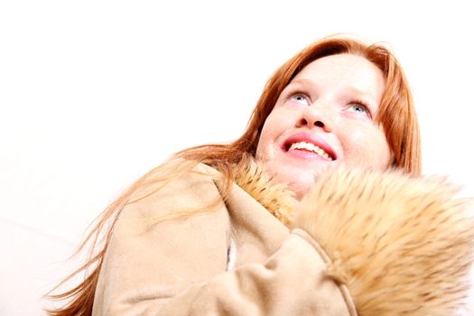 A attractive young, redhead woman in Winter clothing.  