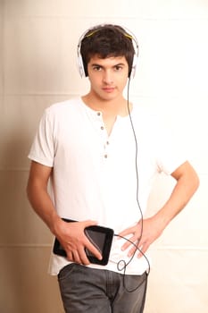 A young, latin man with a Tablet PC and headphones
