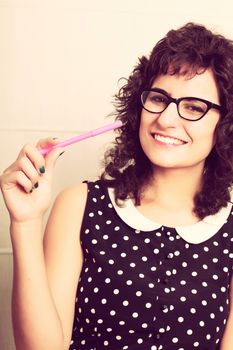 A young woman in a vintage dress holding a pen. Retro style Photo.