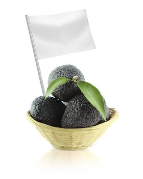 Healthy and organic food concept. Fresh Avocados with leaves on a Dish of straw with flag showing the benefits or the price of fruits.