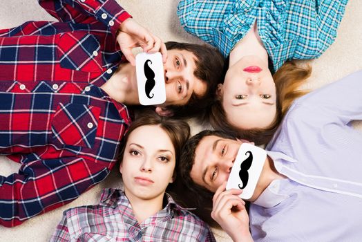 four young men lie together, applied to the face plate with a mustache
