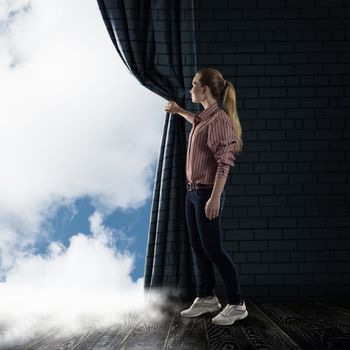 image of a young woman pushes the curtain looking at clouds