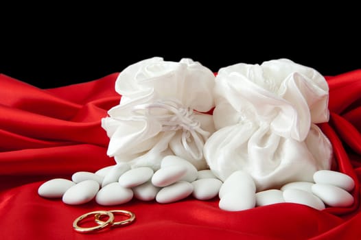  wedding rings and wedding favors on  elegant fabric background