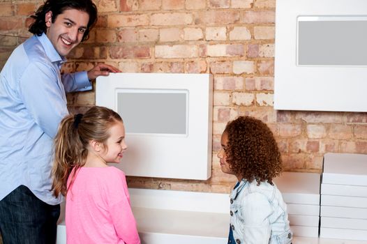 Father teaching daughters how to use digital menu