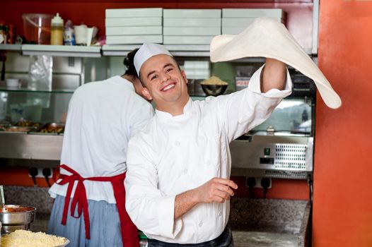 Chef makes the pizza dough spin in the air