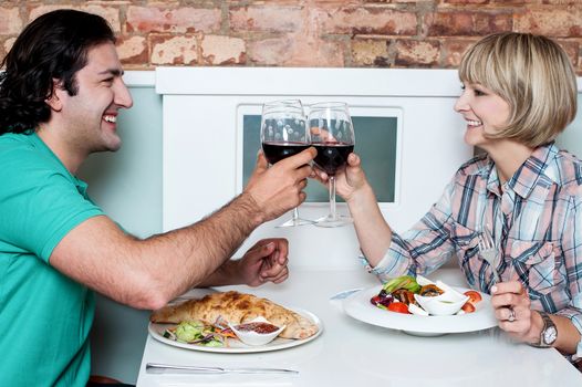 Beautiful couple toasting with wine in restaurant