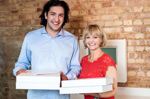 Young couple holding packed pizza boxes