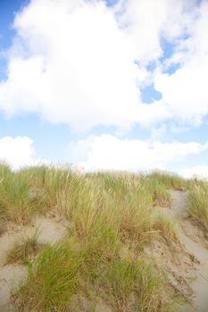 Dunes with sand and cloudy blue sky