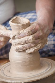 Hands of a potter, creating an earthen jar on the circle