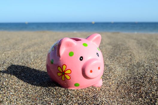 Piggy Bank on the Beach Saving for Vacation Concept