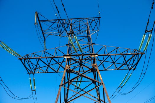 Electricity pylon against the blue sky background.