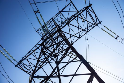 Electricity pylon against the blue sky background.