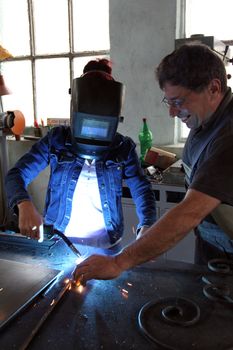 Two workers welding metal construction 