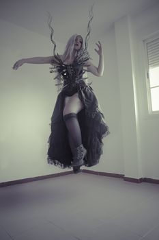 Woman with white hair and black corset floating in an empty room