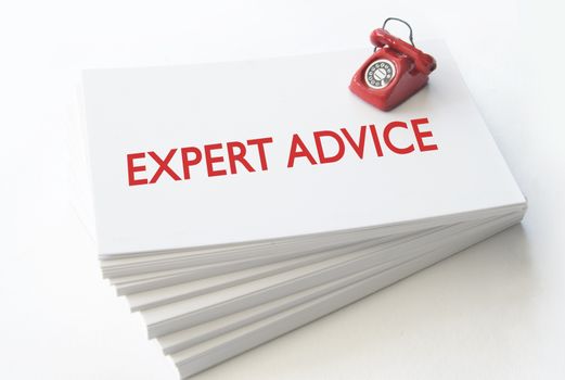 Small telephone on top of a stack of business cards with expert advice