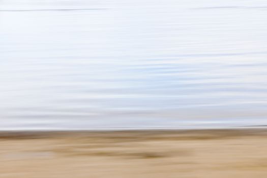 Background image of sand and water created by horizontal in-camera motion blur