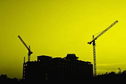 Industrial construction cranes and building silhouettes