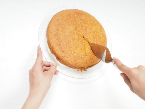 Female person cutting a slice from fresh baked cake
