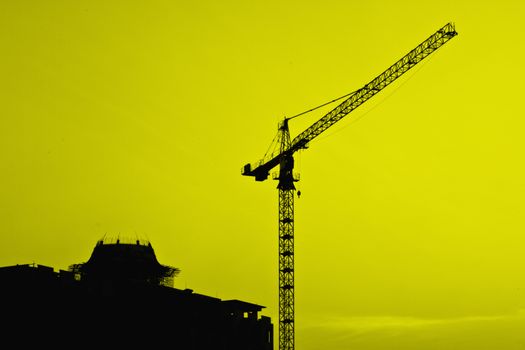 Industrial construction cranes and building silhouettes