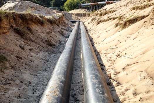 A unfinished pipe line construction with sand around it