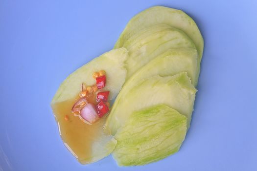 mangoes with sauce, mangoes dipped into a sweet fishy paste with dried shrimp and red onions in plate