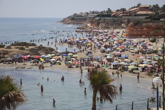 LA ZENIA, ORIHUELA, COSTA BLANCA, SPAIN ON JULY 29 2012: Beach crowded with sun-loving holidaymakers on July 29, 2012 in La Zenia, Spain.