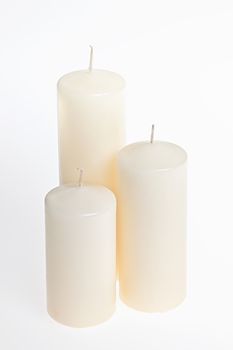 Three new white candles of various height