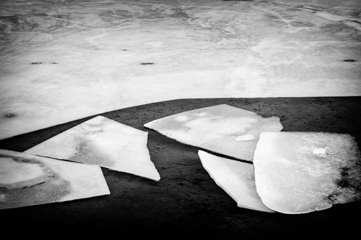 Black and white image of broken ice pieces in dark water