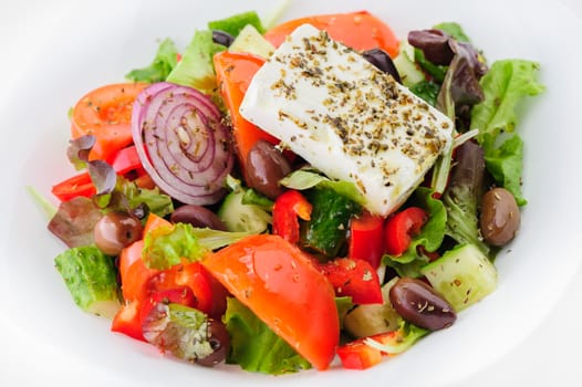 closeup of greek salad with large piece of feta