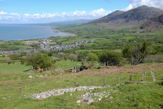 The village of Trefor nestled below the flanks of Gyrn Ddu with Caernarfon bay leading off into the distance. Trefor, Lleyn peninsular, Wales, UK.