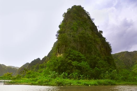 Travelling along rice fields on Tam Coc stream, Ninnh Binh, Vietnam.