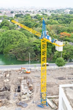 Crane and building construction site in green natural area
