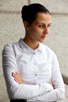 Portrait of a businesswoman in a white blouse on a gray background