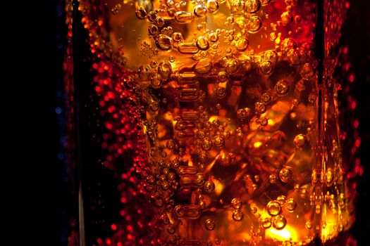 edge of a glass with a drink on the black background