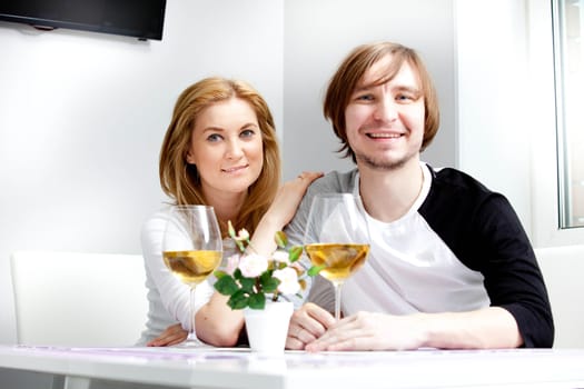 young woman in home having meal and wine with her husband