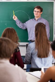 Teacher at university in front of a chalkboard