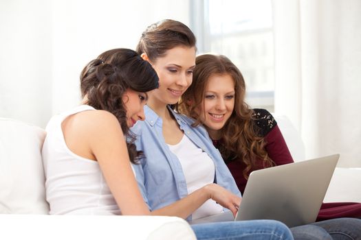 three young  woman resting with notebook on sofa, at campus