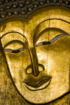 A wooden golden Buddha face.