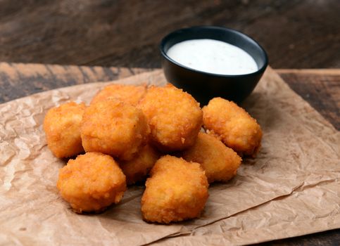 Chicken nuggets with garlic sauce on old wooden background