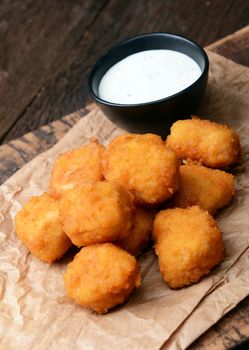 Chicken nuggets with garlic sauce on old wooden background