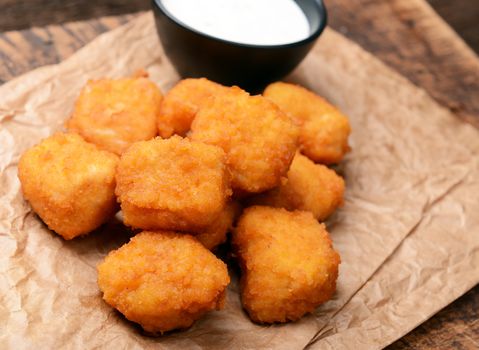 Chicken nuggets with garlic sauce on old wooden background