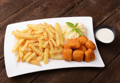 Fries with chicken nuggets and salad