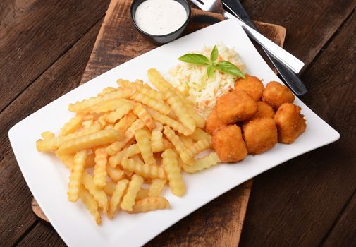 Fries with chicken nuggets and salad