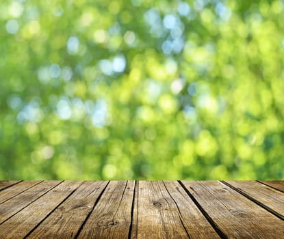 Empty wooden deck table with fresh green background