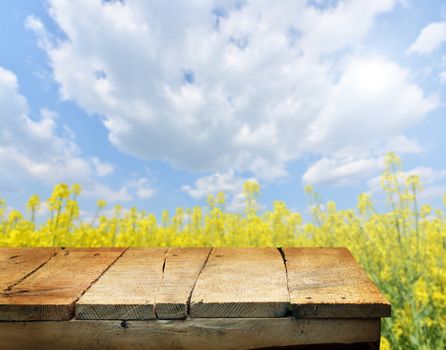 Empty wooden deck table with spring flowers in background