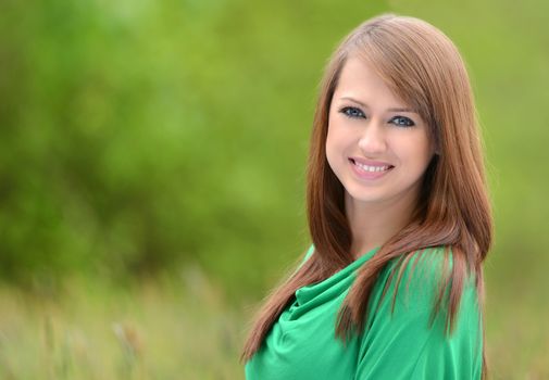 beautiful brunette posing against fresh green background