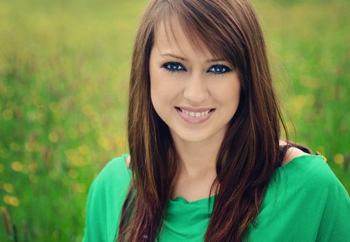 beautiful brunette posing against fresh green background