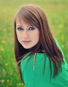 beautiful brunette posing against fresh green background